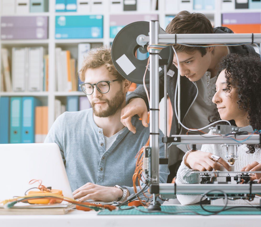 University students working with a 3D printer higher education